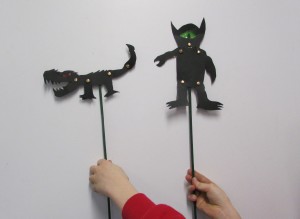 boy's hands holding up monster shadow puppets