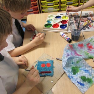 Painting clay tiles at the children's art school after school club led by artist Karen Logan